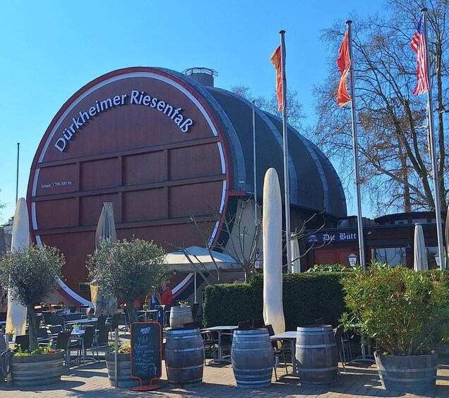 A large building with a circular facade and flags. 5