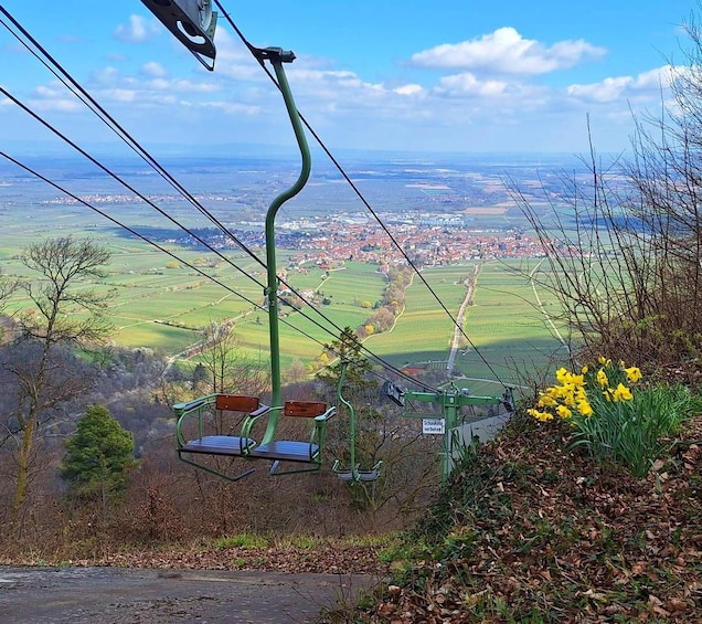 A chairlift with a scenic view of a town and fields below. 2