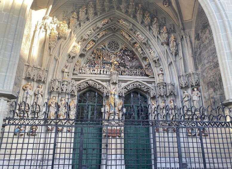 A Gothic cathedral facade with intricate sculptures and a green door. 4