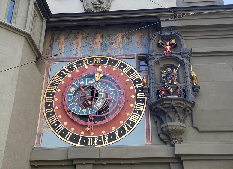 A large, ornate astronomical clock with zodiac symbols and a statue of a deity. 1