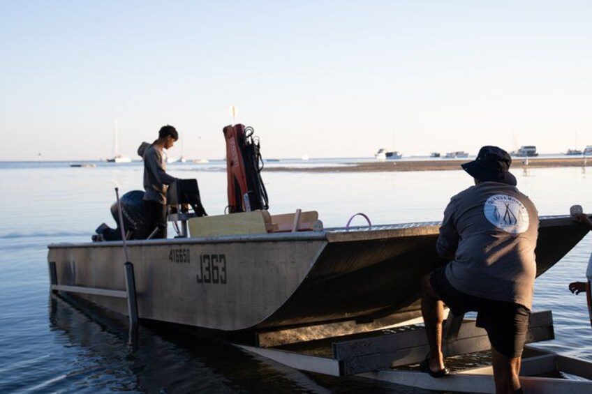 A boat with the number 41650 on it, docked at a pier with calm water and a clear sky. 2