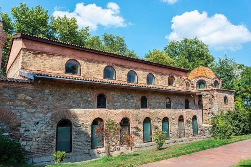 A historic stone building with arched windows and a dome. 1