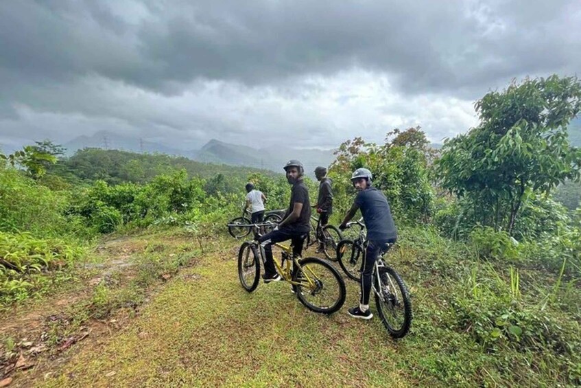 Un grupo de ciclistas en un sendero cubierto de hierba, con un paisaje montañoso al fondo. 5
