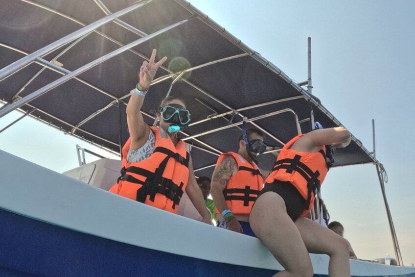 People on a boat wearing life jackets. 4