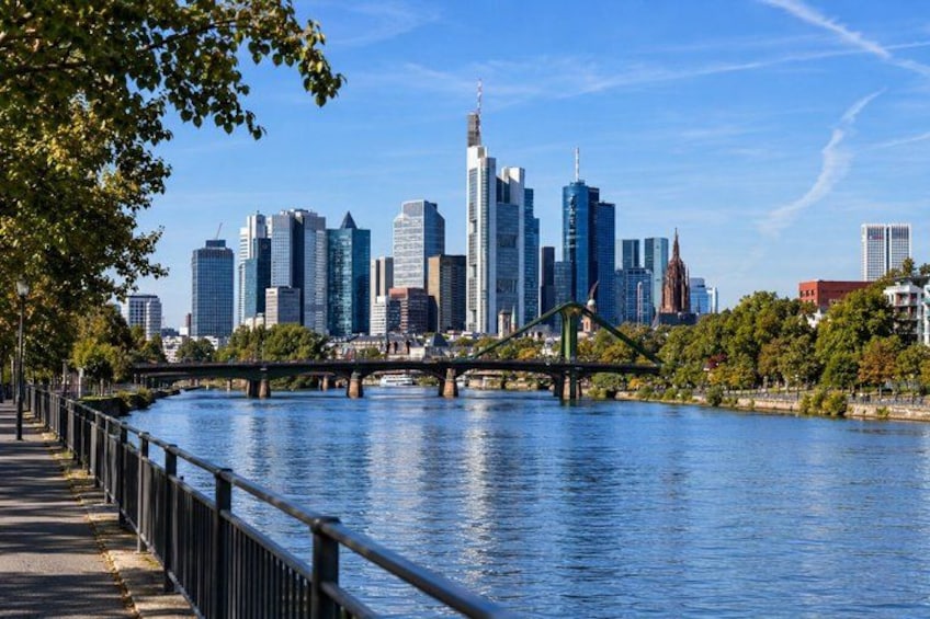 A river with a bridge, a city skyline, and a park with trees. 4