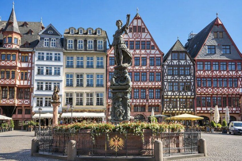 A town square with a statue, traditional half-timbered buildings, and cobblestone streets. 5