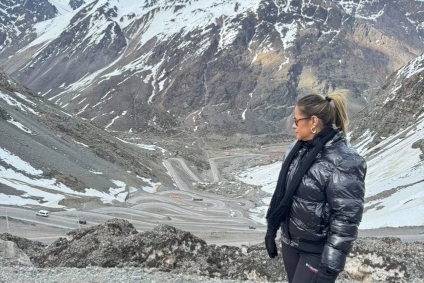 A person standing on a rocky terrain with a mountainous landscape in the background. 5