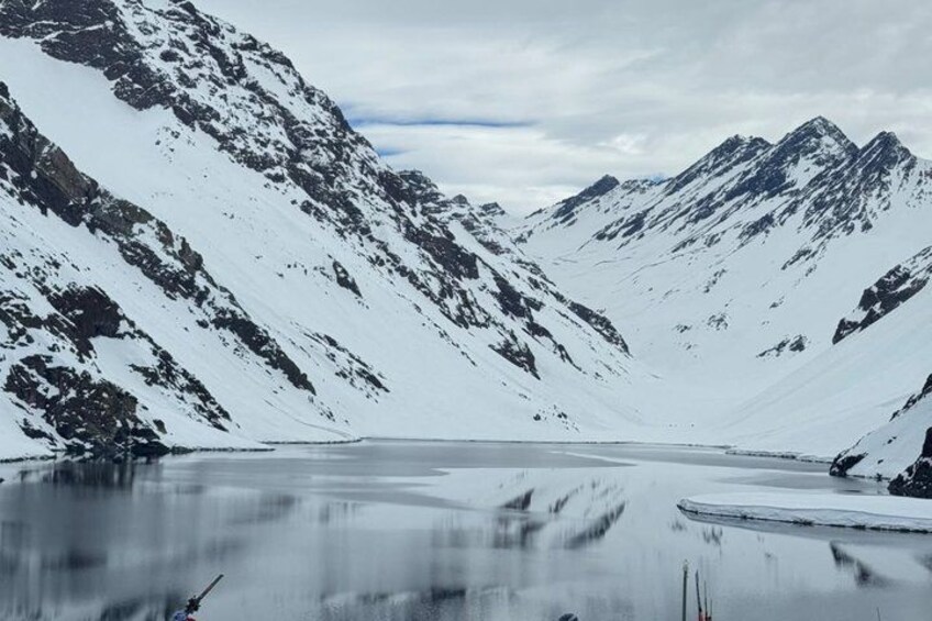 A snow-covered mountain range with a frozen lake in the foreground. 3