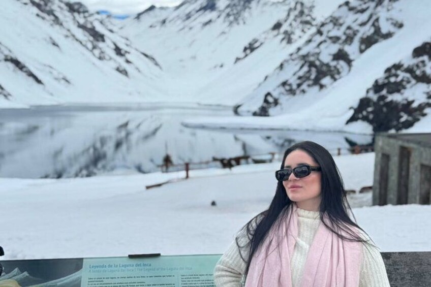 A person standing in a snowy landscape with mountains in the background. 1
