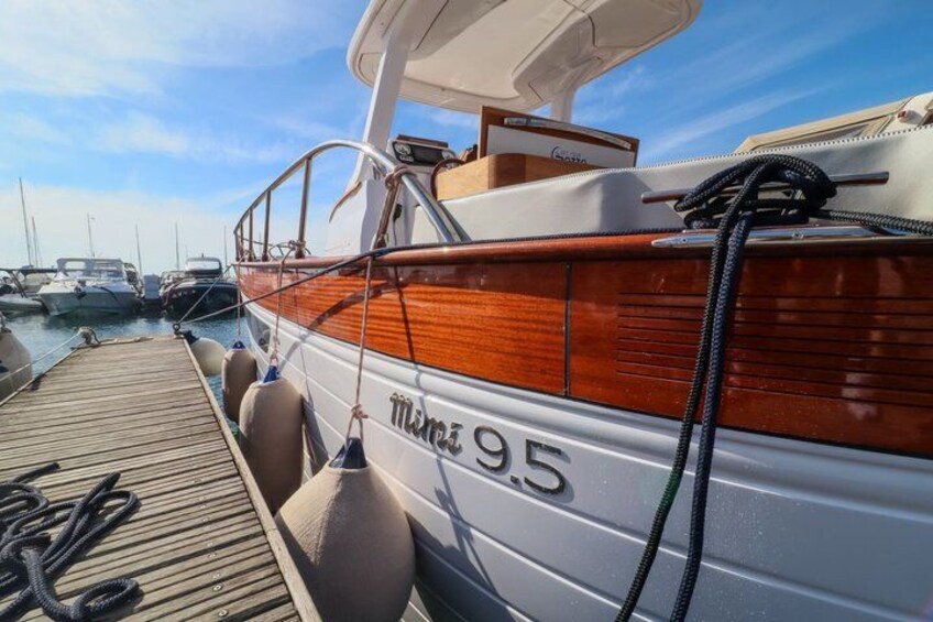A wooden boat docked at a marina with the number 95 visible on its side. 5