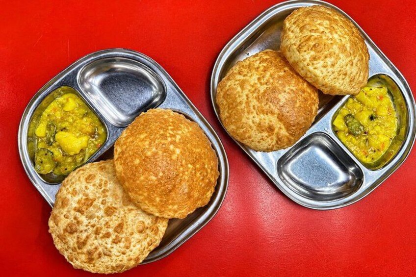 A meal with two metal plates containing chapatis and dal. 5