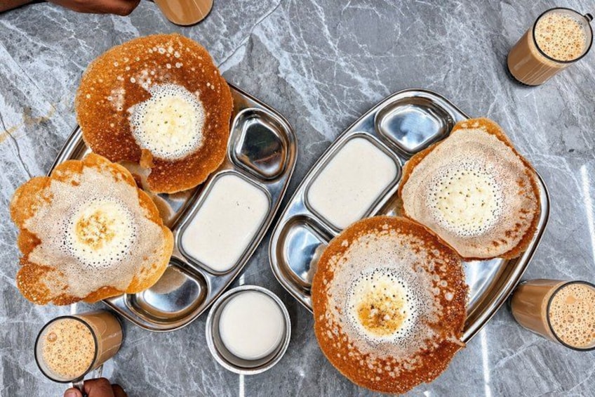 A metal tray with three dosas and two glasses of coffee. 2