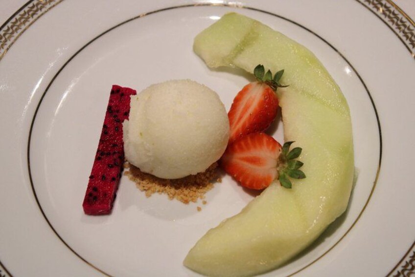 A dessert plate with a scoop of ice cream, a slice of banana, and a strawberry. 4