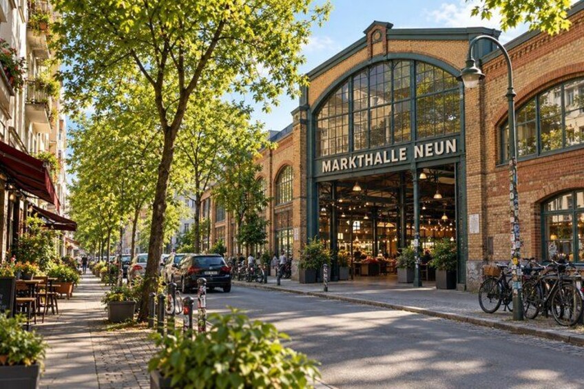 A street with a building labeled 'MARKTHALLE NEUN' and bicycles parked outside. 3