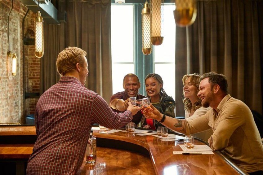 A group of people toasting at a bar with a rustic interior. 1
