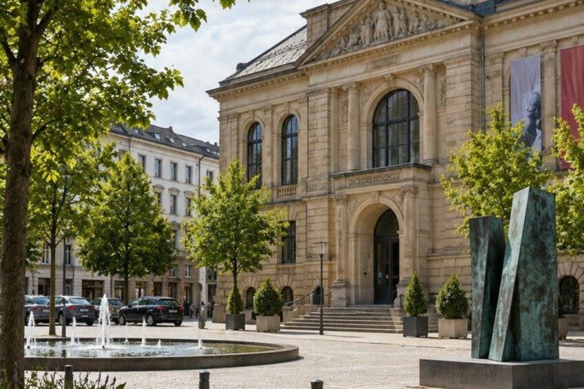 A classical building with arched windows and a fountain in the foreground. 2