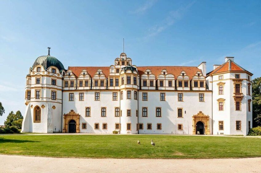 A large, ornate building with a central dome and multiple wings, surrounded by a well-maintained lawn. 1