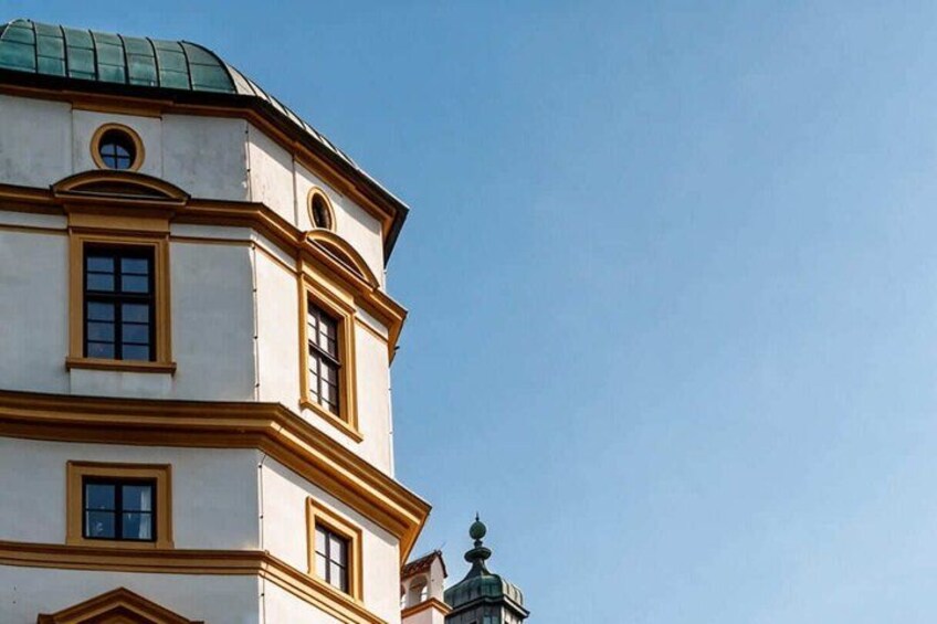 A building with a green dome and a white facade with gold trim. 2