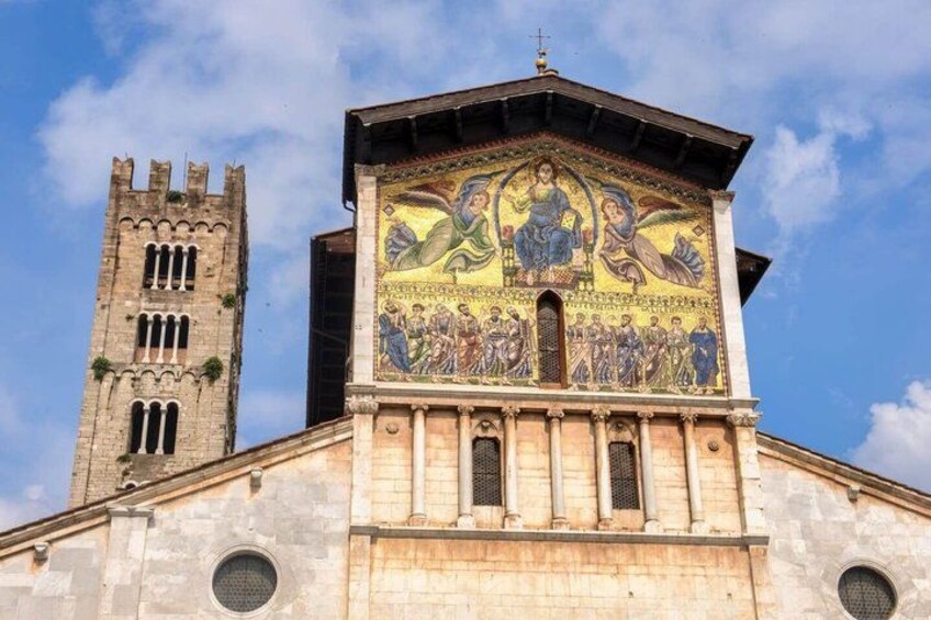 A church with a tall bell tower and a mosaic depicting religious figures. 5