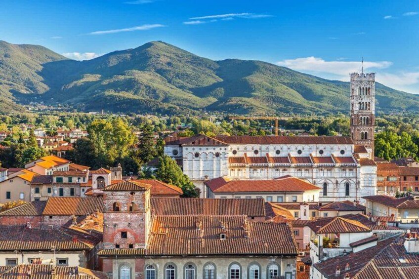 A town with historic buildings, a prominent church, and a tower. 1
