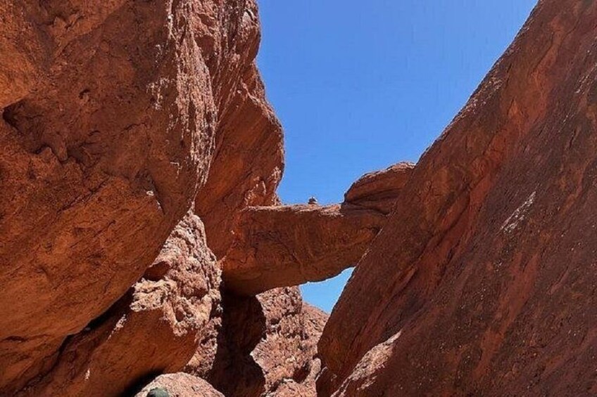 A red rock formation with a narrow passageway. 4