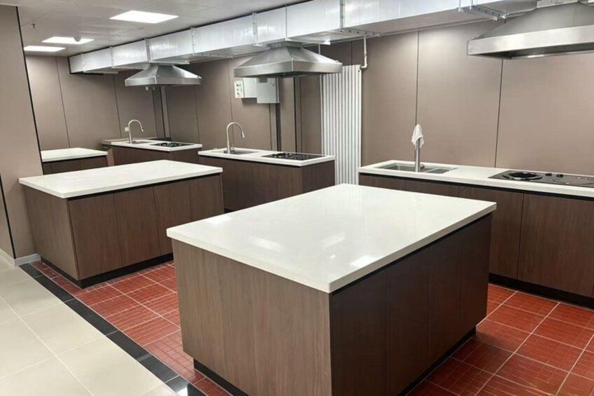 A modern kitchen with a central island, built-in sinks, and stainless steel appliances. 5
