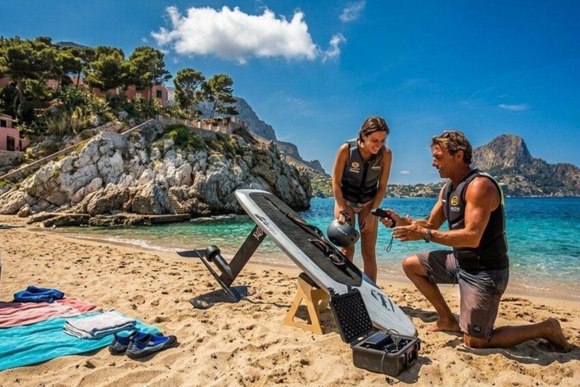 A beach with a kayak, a towel, and a person kneeling. 5