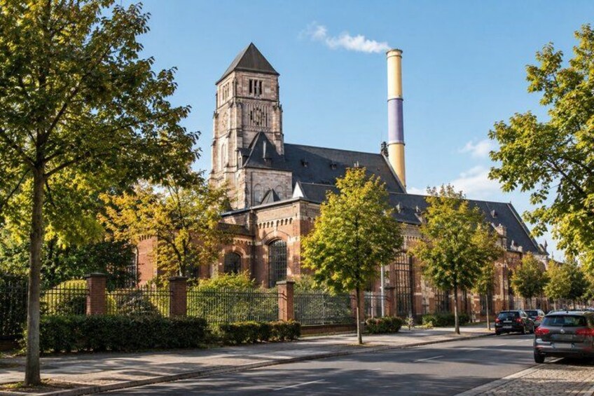 A historic church with a clock tower and a tall chimney. 2