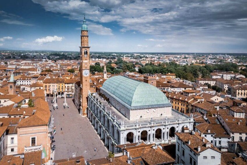 A historic square with a prominent clock tower and a large dome structure. 1