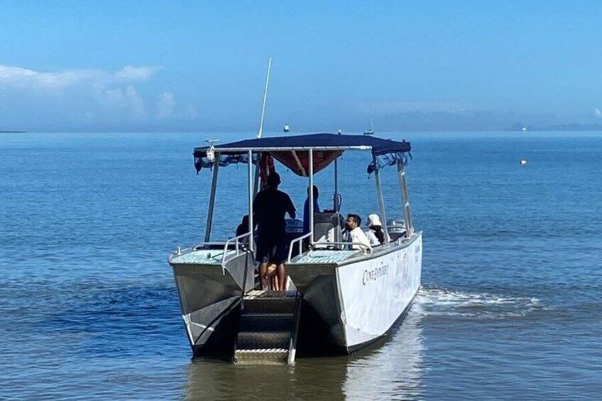 A small boat with people on board, moving through calm water. 4