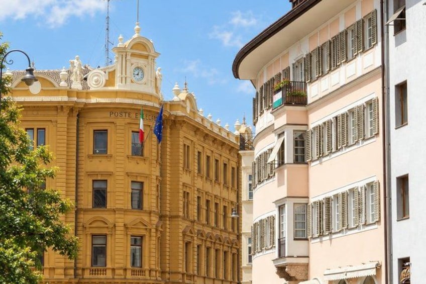 A historic building with ornate architecture, a clock tower, and flags. 4