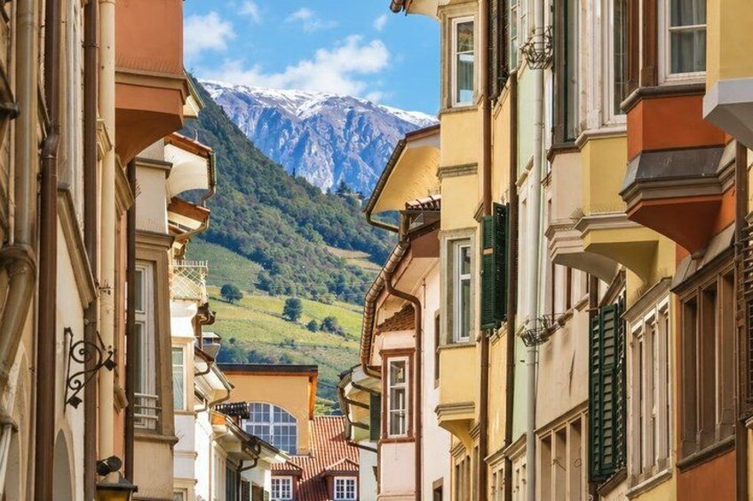 A street with buildings, a mountain, and a clear sky. 5