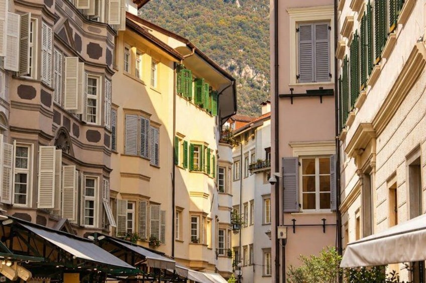 A street with buildings, a mountain in the background, and a café with outdoor seating. 3