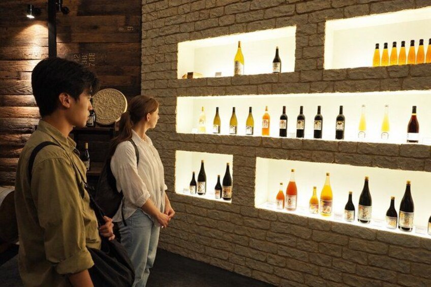 A wall with shelves displaying various bottles. 4