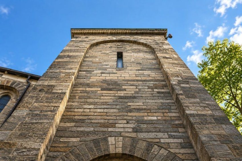 A tall brick tower with a small window and an arched entrance. 4