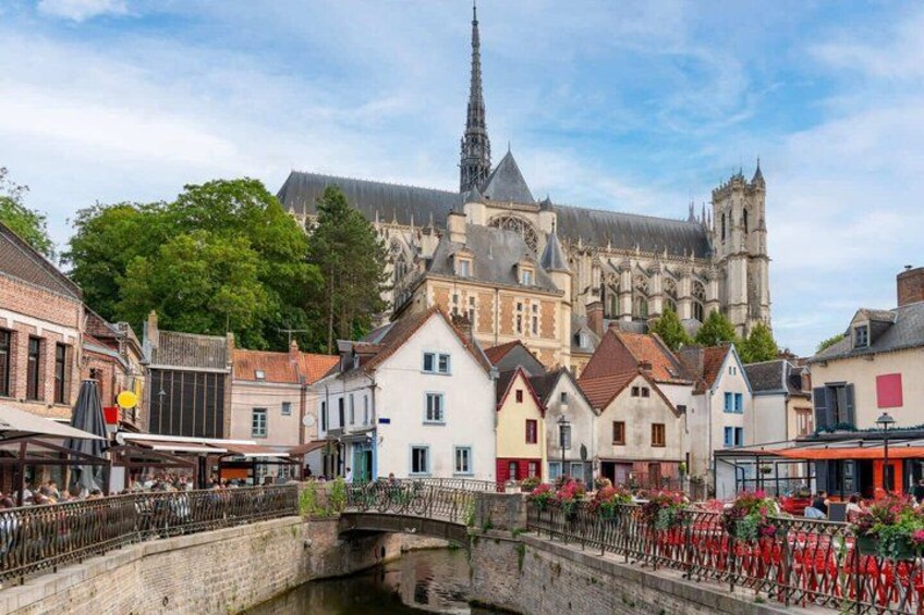 A historic town with a prominent cathedral, a bridge, and traditional buildings. 3
