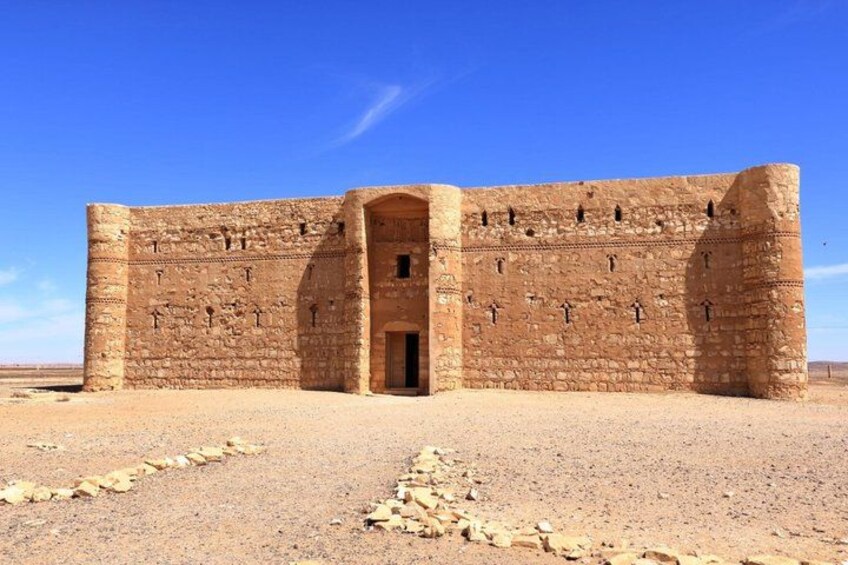 A large, ancient stone structure with a central doorway, surrounded by a barren landscape. 3