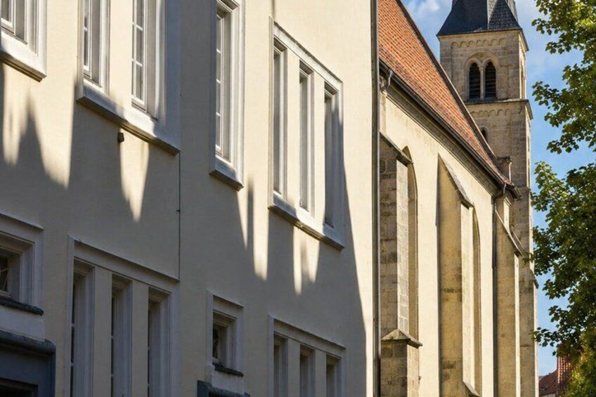 A building with multiple windows and a tower with a pointed roof. 2