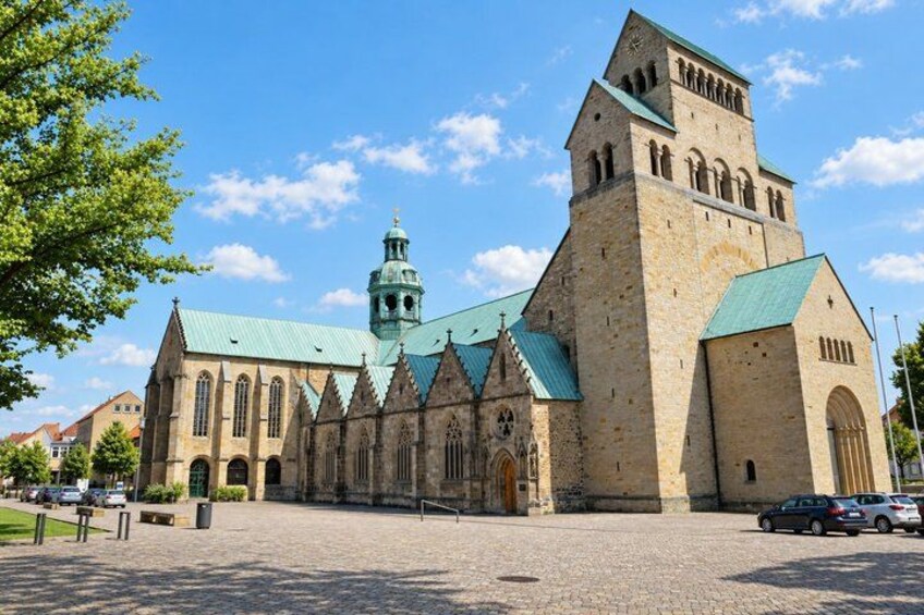 A historic church with a prominent tower and a green roof. 4