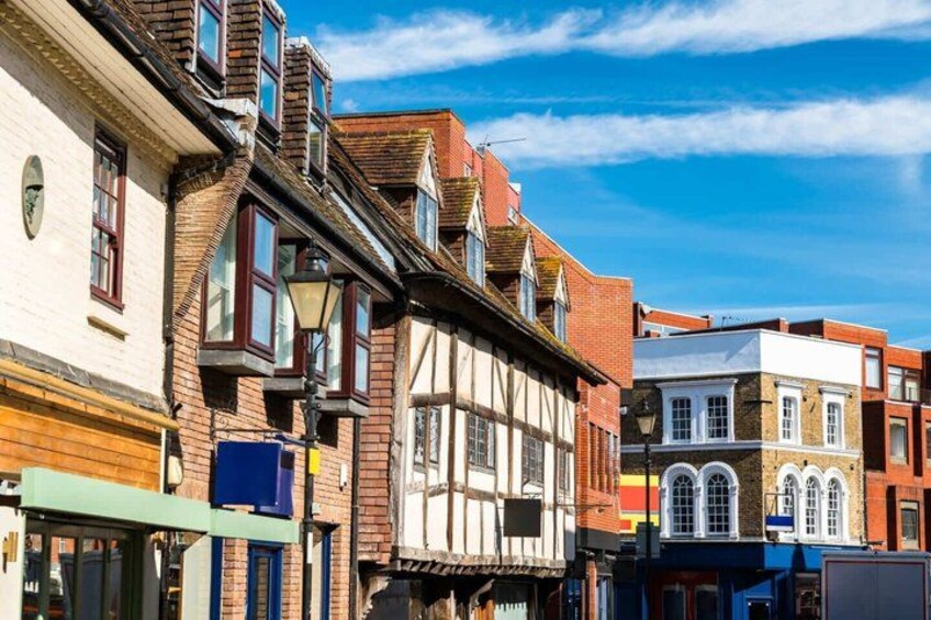 A street with historic buildings, a clear blue sky, and a street lamp. 3
