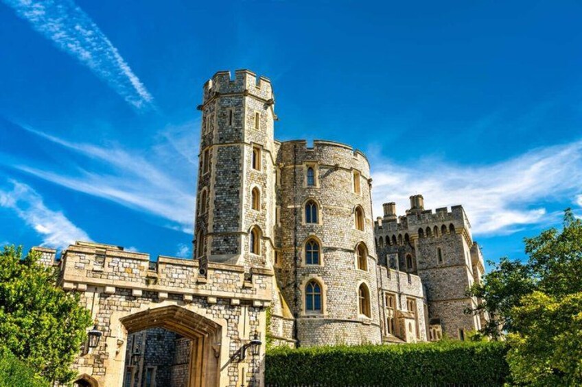 A historic stone castle with a prominent tower, arched entrance, and crenellated walls. 2