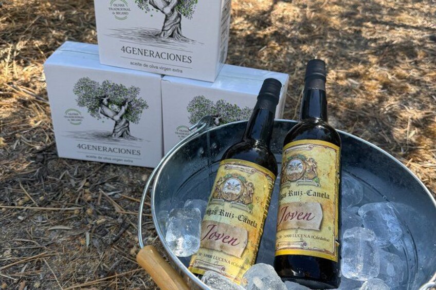 Two bottles of wine in a metal bucket with ice, surrounded by boxes labeled '4 GENERACIONES'. 3