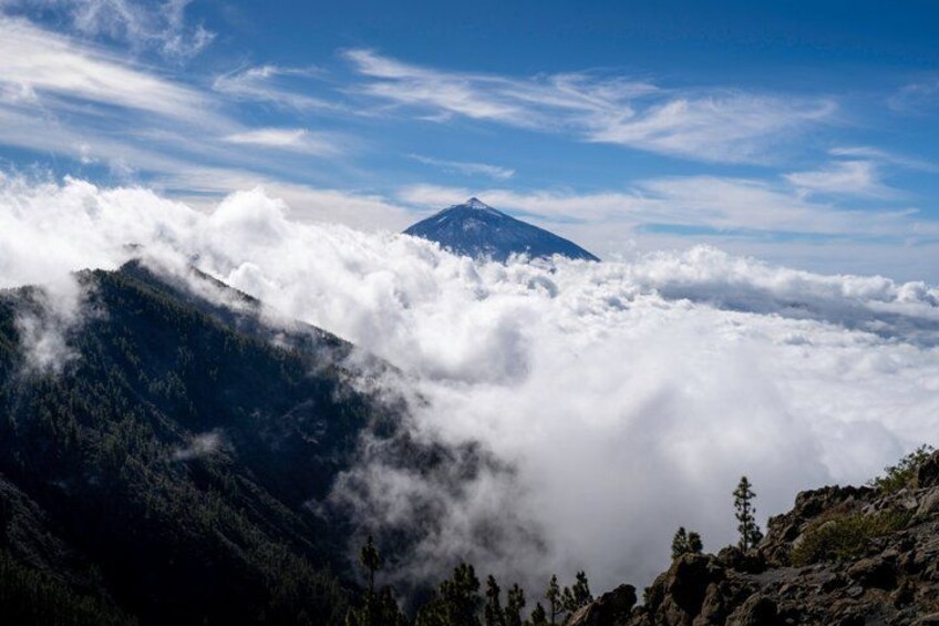 A mountain with a peak, clouds, and forested slopes. 3