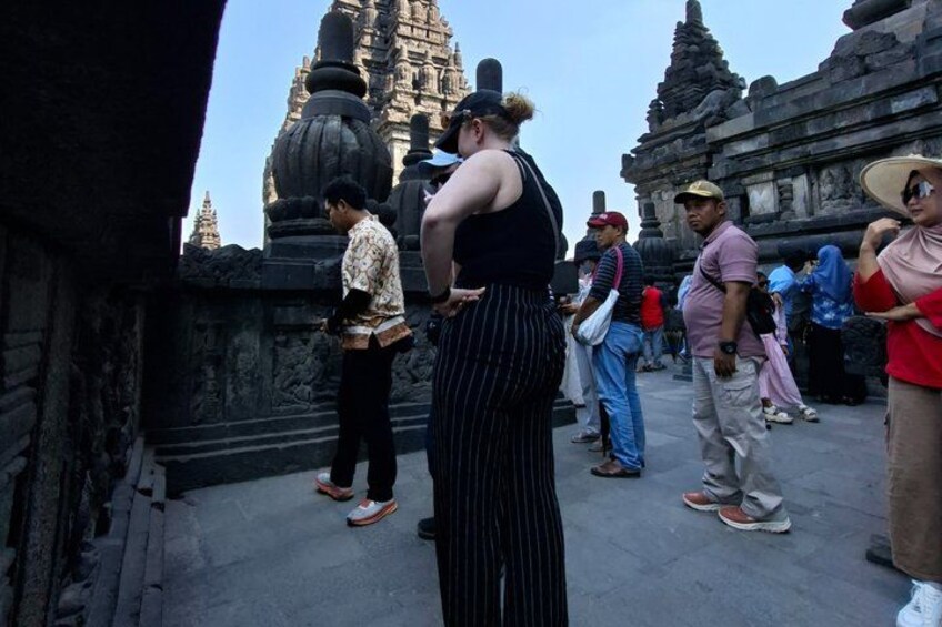 Tourists at a historical temple site with stone architecture and a clear sky. 2