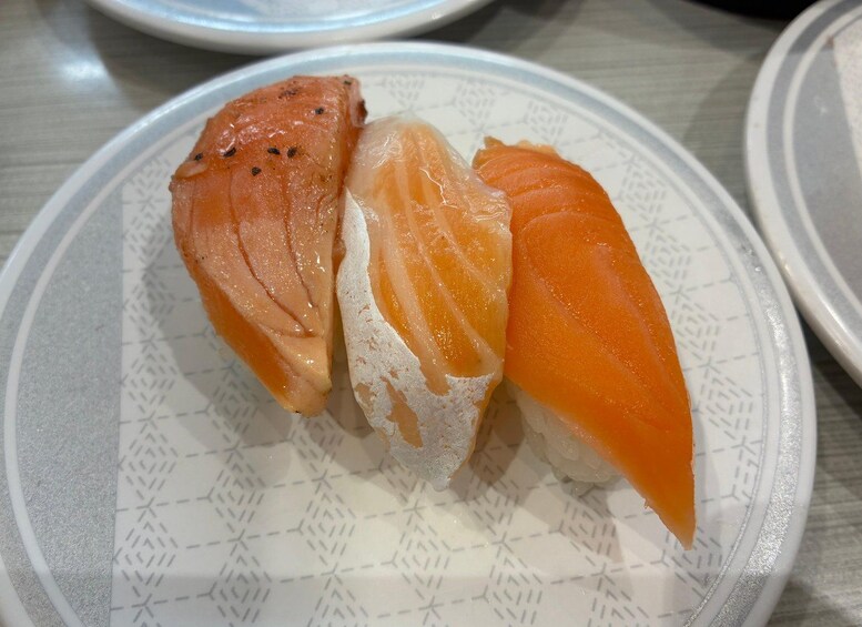 Tre stykker sushi på en tallerken. 5