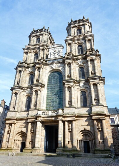 A large historic cathedral with two prominent towers, a large central arch, and detailed stone carvings. 5