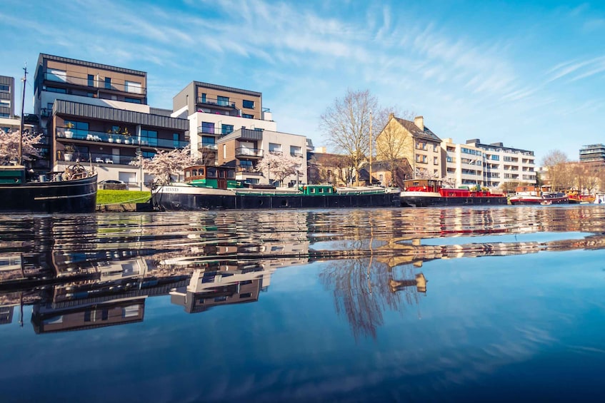 A canal with boats, modern buildings, and reflections on the water. 1