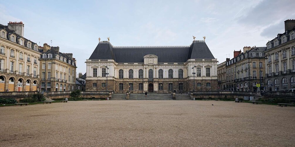 A large historic building with a symmetrical facade, arched windows, and a central entrance. 4
