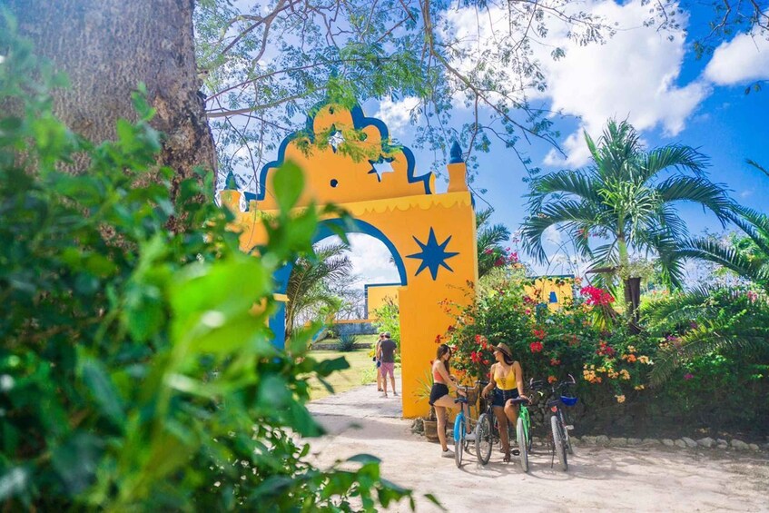 A colorful archway with a star design, surrounded by lush greenery and palm trees. 3