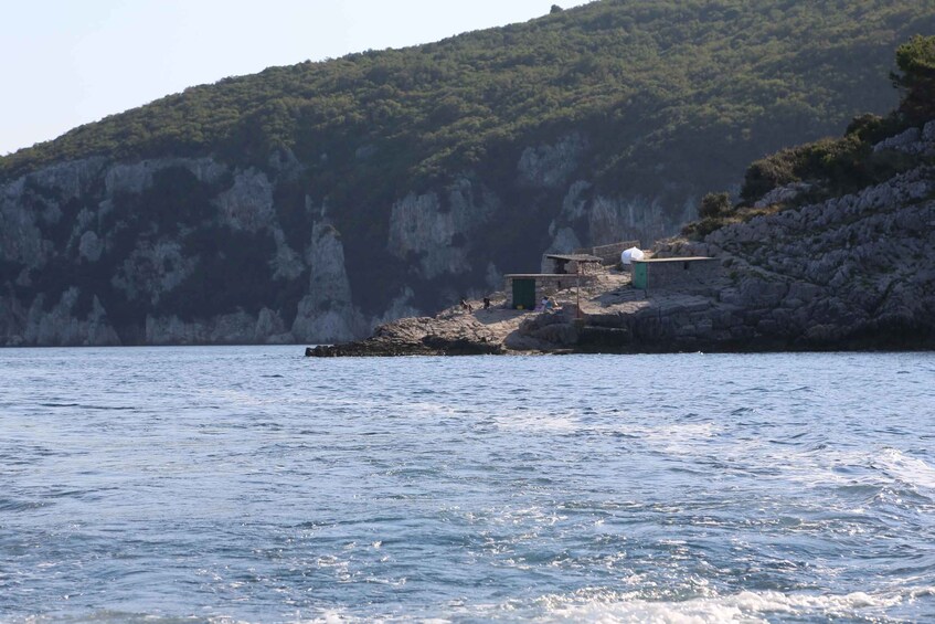 Un paysage côtier avec des falaises rocheuses, un petit bâtiment et une mer calme. 5